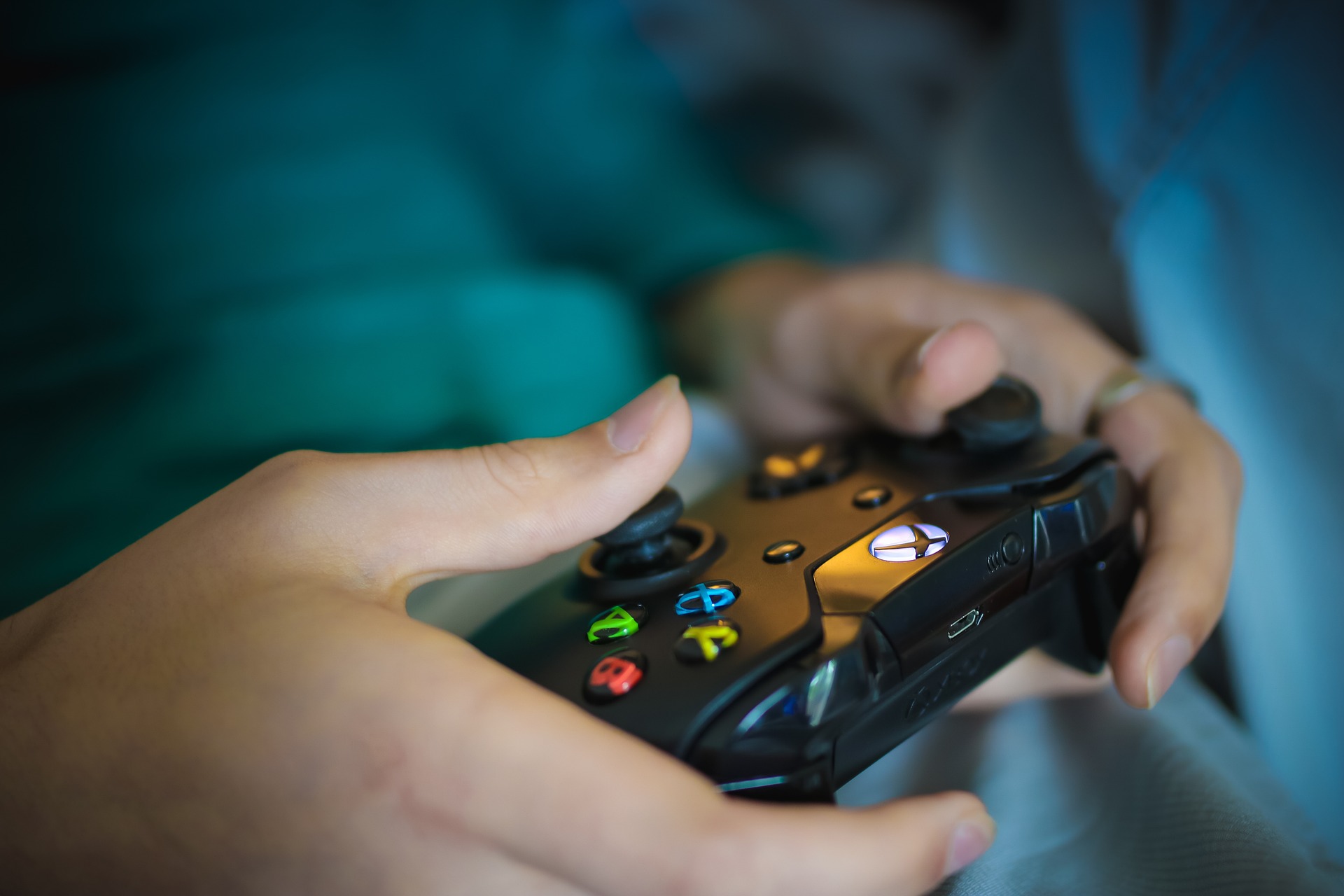 Image by Olichel from Pixabay Two hands holding a controller for a gaming console.