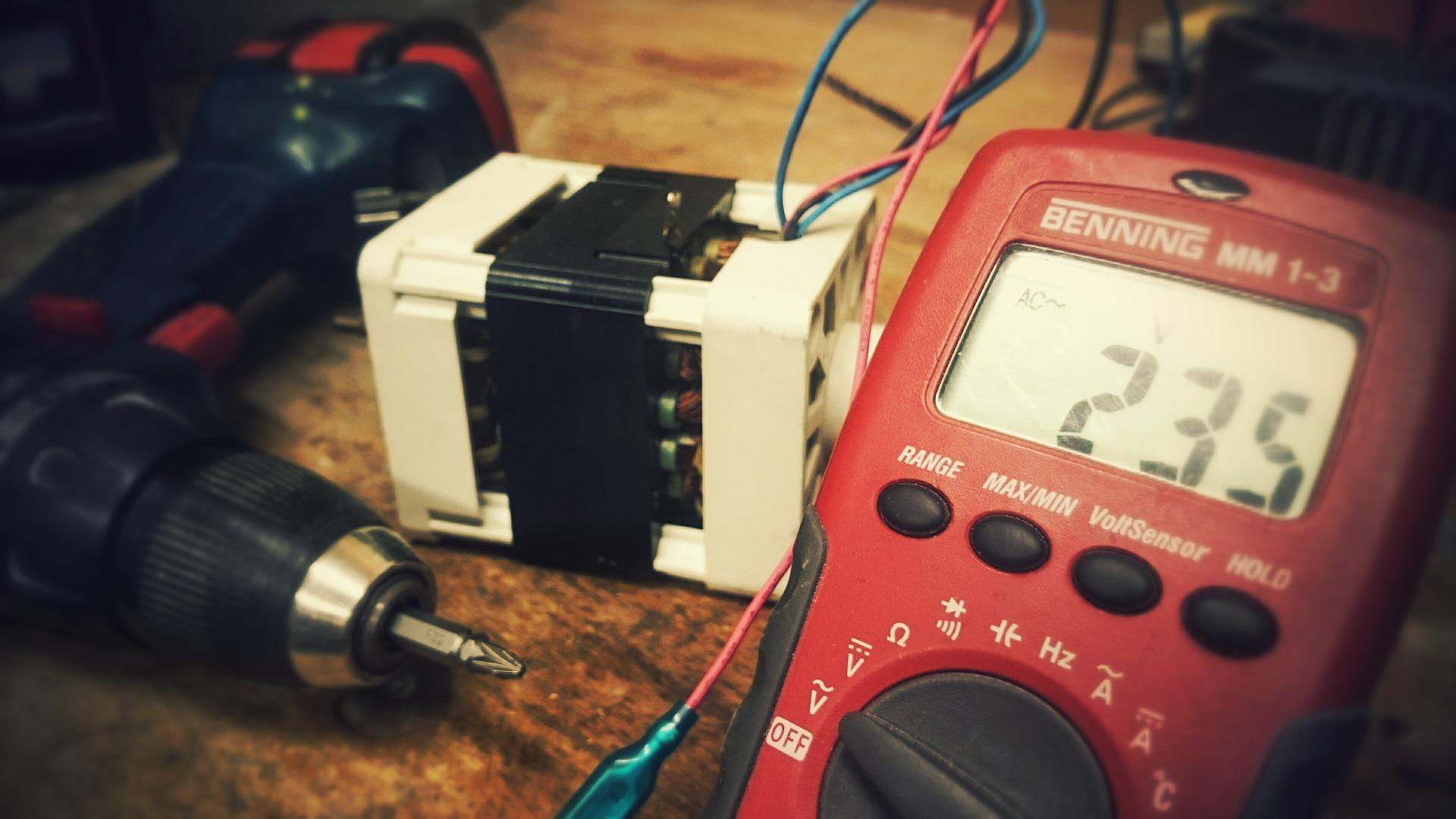 A multi meter measuring an assembled component.